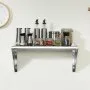 Estante de acero inoxidable VEVOR en la cocina con botes y recipientes para especias, debajo de un reloj.