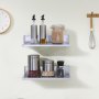 Estante de acero inoxidable VEVOR con tarros de cocina y recipientes para especias montados en una pared de color claro.