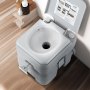 Inodoro portátil VEVOR con descarga de agua sobre suelo de madera, tapa abierta que muestra el interior del inodoro.