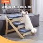 Perro blanco subiendo las escaleras para mascotas VEVOR junto a un sofá gris, con escalones alfombrados en azul y marco de madera.