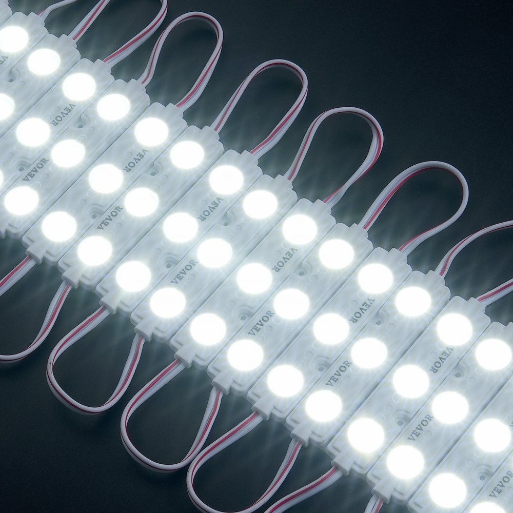 Luces LED de escaparate VEVOR dispuestas en filas con conectores con cables blancos sobre un fondo oscuro.