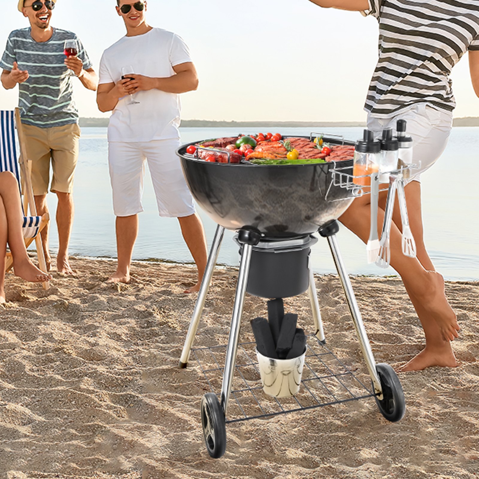 Parrilla de carbón VEVOR en una playa de arena con amigos disfrutando de una reunión de barbacoa junto al agua.