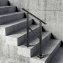 Barandilla de escalera exterior VEVOR negra instalada en escaleras de hormigón con pared texturizada.