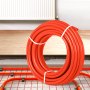 Tubo pex VEVOR enrollado en rojo colocado cerca del sistema de calefacción por suelo radiante.