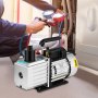 Técnico que utiliza bomba de vacío VEVOR con manómetro múltiple en reparación del sistema HVAC.