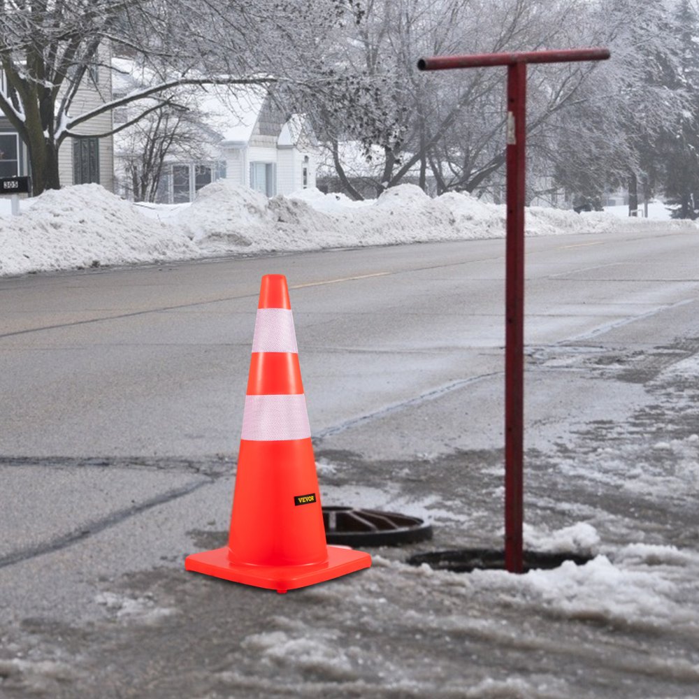 Conos de seguridad VEVOR en una calle helada junto a un poste rojo y montones de nieve.