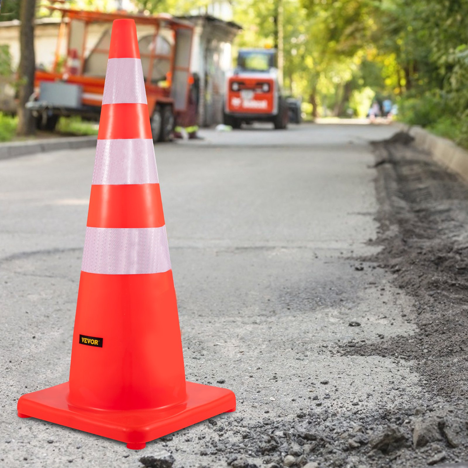 Conos de tráfico VEVOR en una carretera parcialmente pavimentada con vehículos de construcción al fondo.