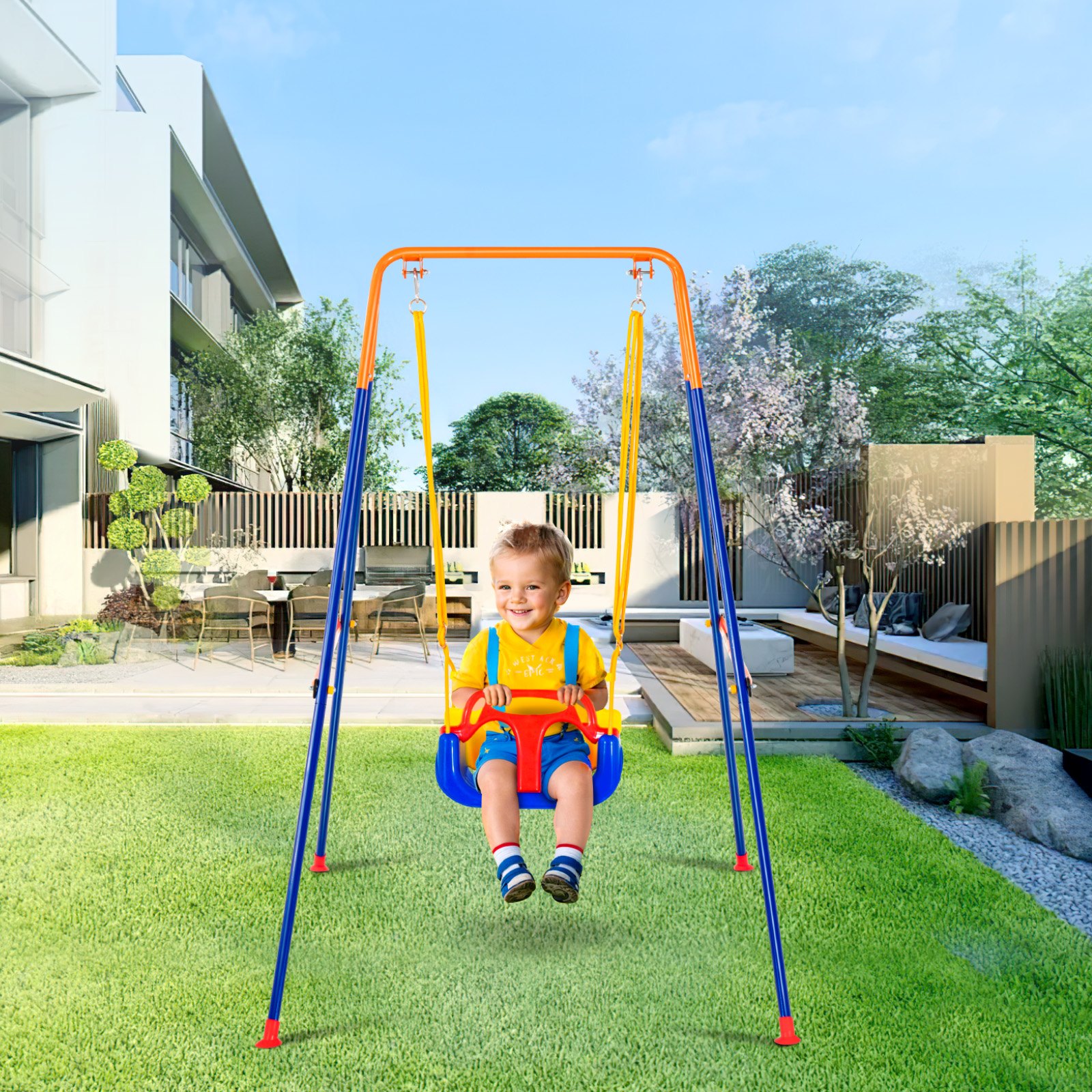 Niño disfrutando de un columpio VEVOR en un jardín trasero con asientos modernos y vegetación pintoresca.