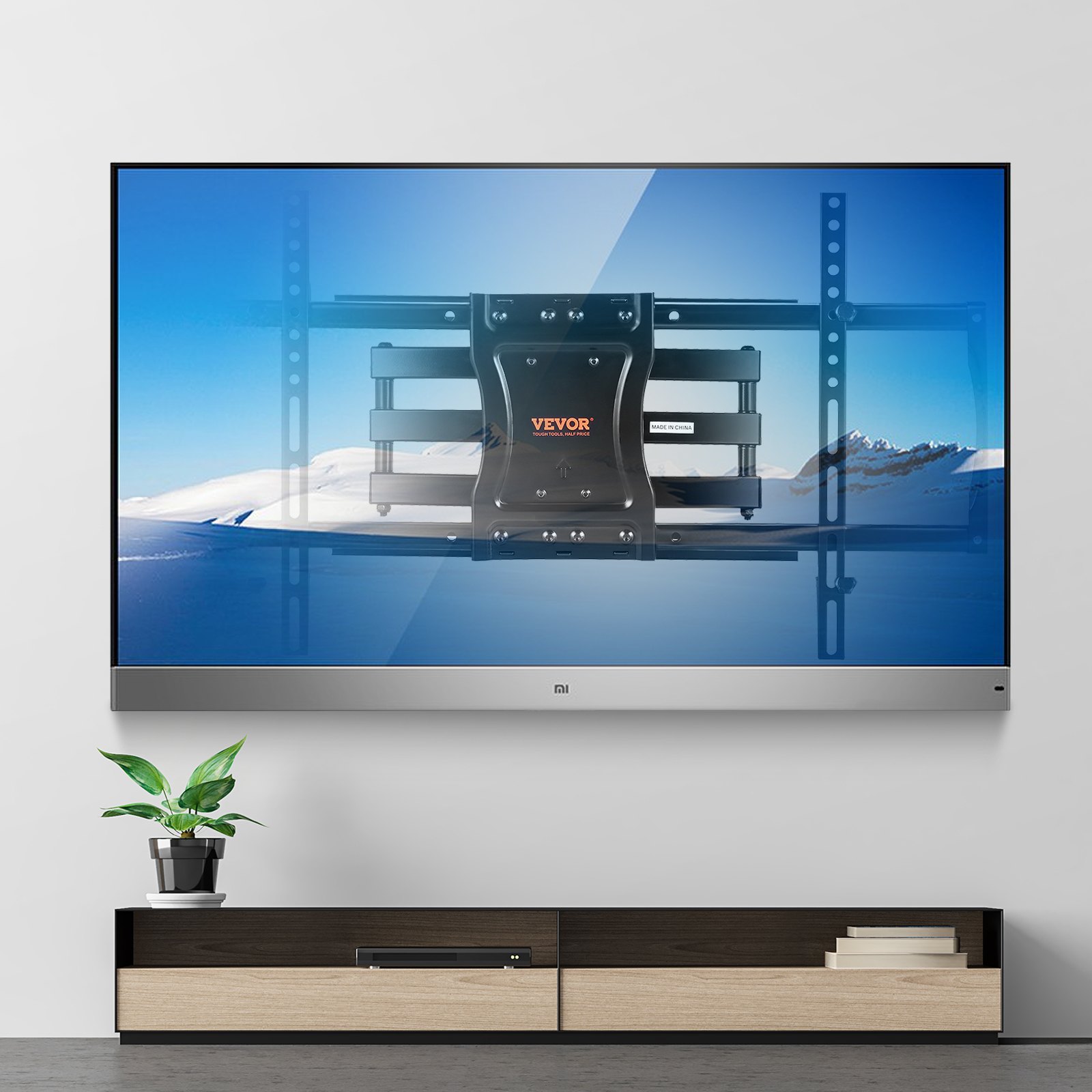 Soporte de TV de movimiento completo VEVOR sobre mueble de TV moderno de madera y negro con planta.