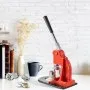 Máquina para hacer botones rojos VEVOR sobre una mesa blanca con libros, una taza y botones terminados cerca.