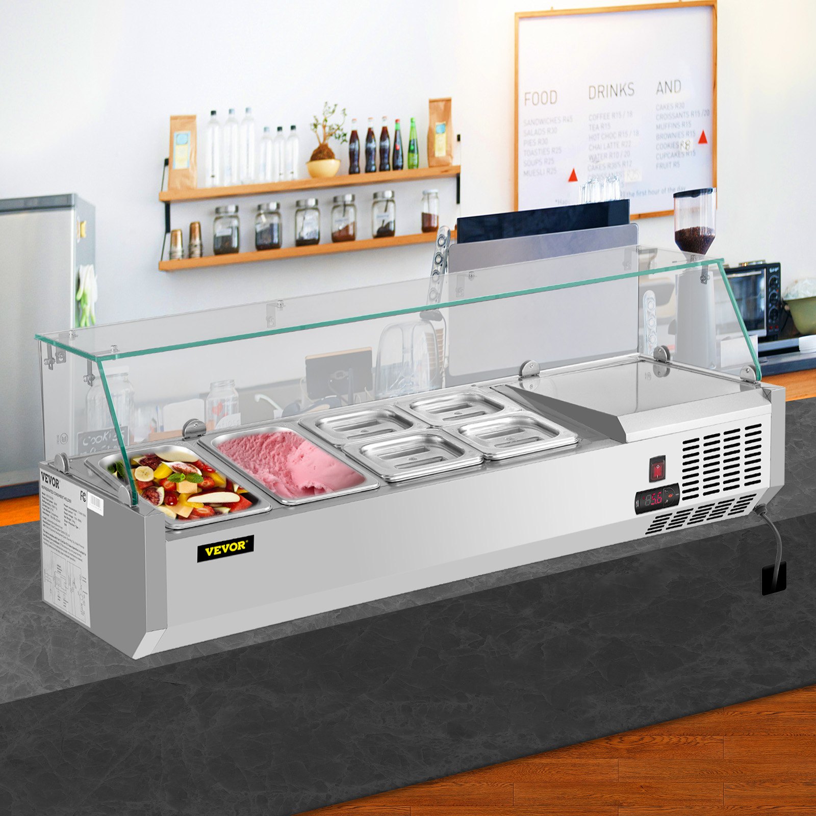 Estación de preparación refrigerada VEVOR con protector de vidrio contra estornudos, llena de alimentos variados en una cocina moderna.