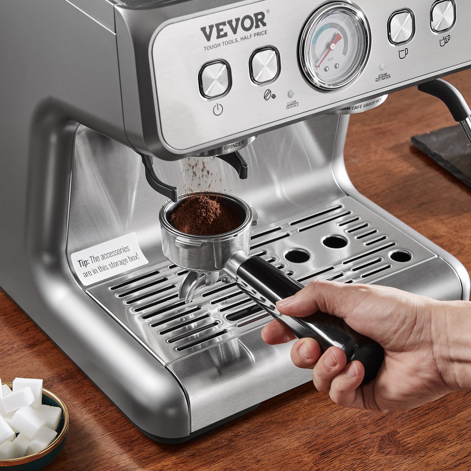 Máquina de café expreso VEVOR con portafiltro que se llena con posos de café y terrones de azúcar sobre una mesa de madera.