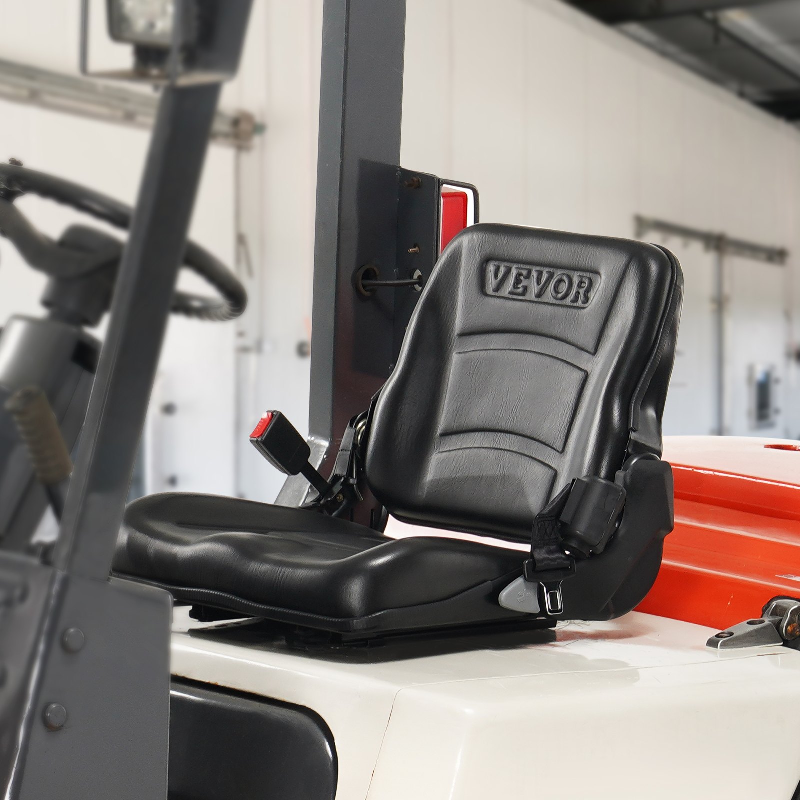 Asiento universal para carretilla elevadora VEVOR en color negro instalado en una carretilla elevadora, con reposabrazos y cinturones de seguridad.