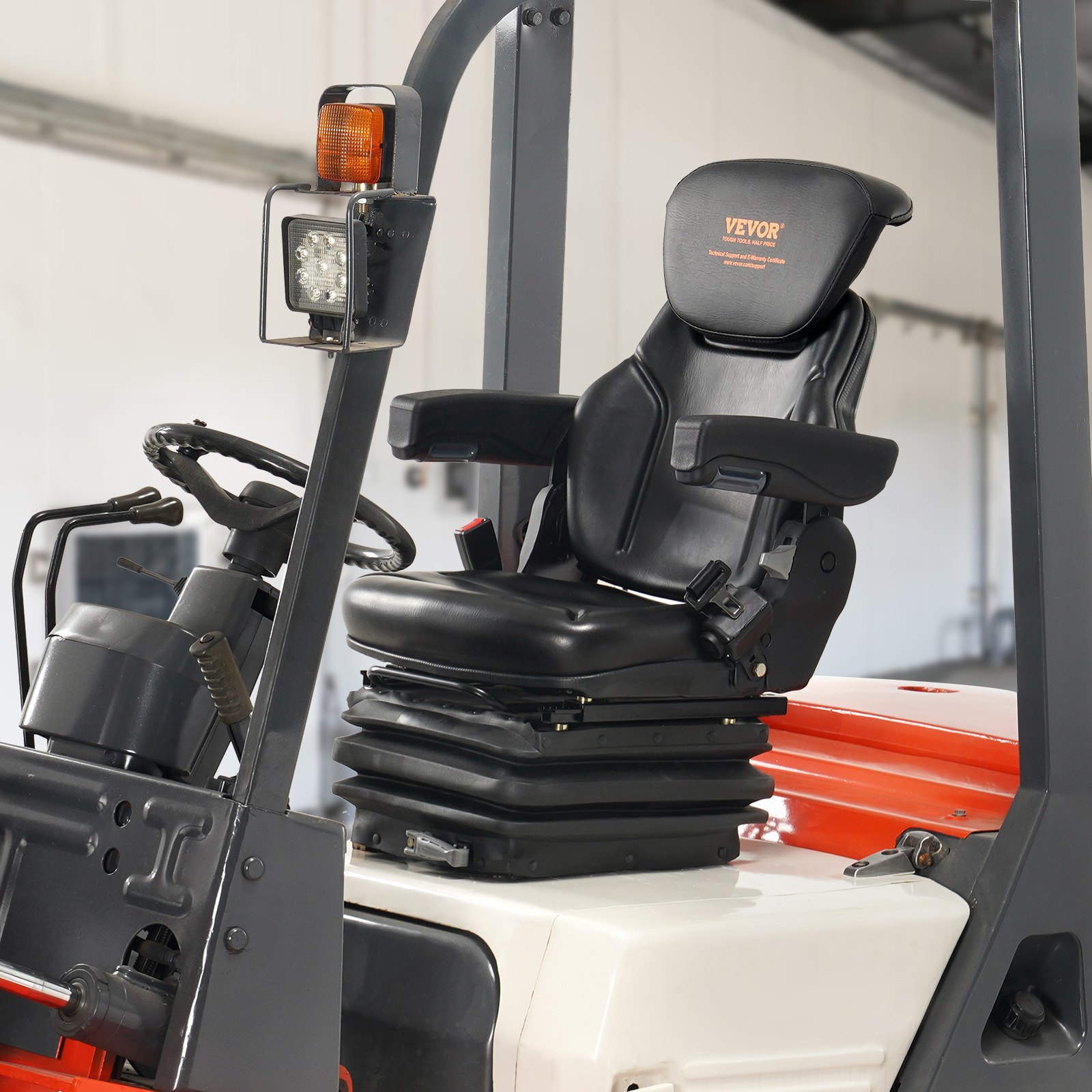 Asiento de tractor universal VEVOR con reposabrazos ajustables en un vehículo industrial en el interior.