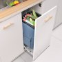 Mueble de cocina abierto que revela un bote de basura extraíble VEVOR lleno de verduras variadas.
