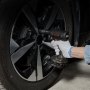 Persona que usa una llave eléctrica con un juego de dados de impacto VEVOR en la llanta de un automóvil, con guante blanco.