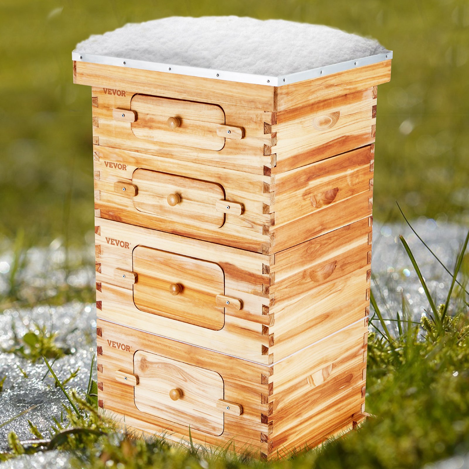 Kit de colmena VEVOR con tres cajas de madera en un campo cubierto de hierba y nieve.
