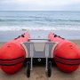 Embarcación hinchable roja con ruedas de lanzamiento de barco VEVOR orientadas hacia el mar.