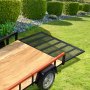 Asistente de elevación de portón trasero de remolque VEVOR en una plataforma de remolque de madera en un jardín cuidado con arbustos verdes.