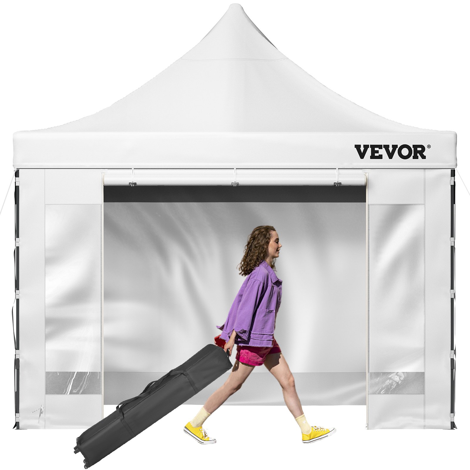 Persona que lleva un estuche negro delante de una gran tienda de campaña emergente VEVOR.