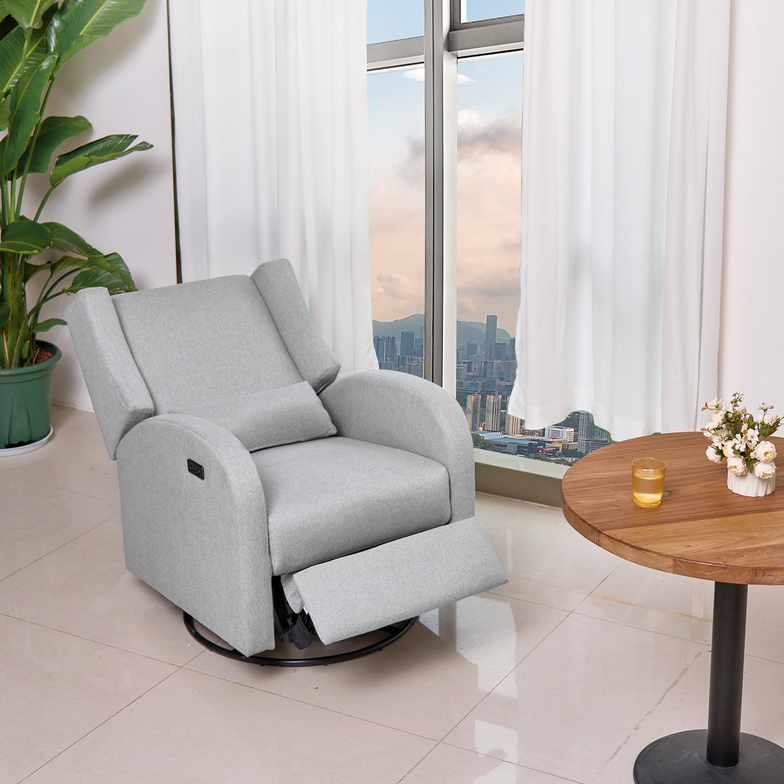 Sillón reclinable VEVOR gris cerca de una ventana con vista a la ciudad, cortinas blancas, mesa redonda de madera, plantas cerca.