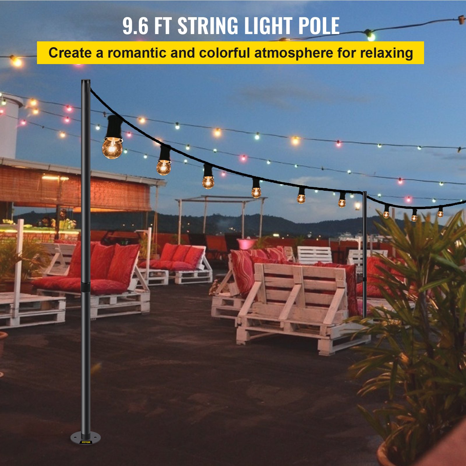 Patio con poste de luz de cadena VEVOR de 9,6 pies y luces de colores, asientos acogedores al anochecer.