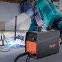 Soldador que utiliza un cortador de plasma VEVOR con equipo de seguridad, mostrando el corte de precisión y el equipo en acción.