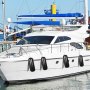 Yate blanco atracado con defensas VEVOR negras en un puerto deportivo muy concurrido.