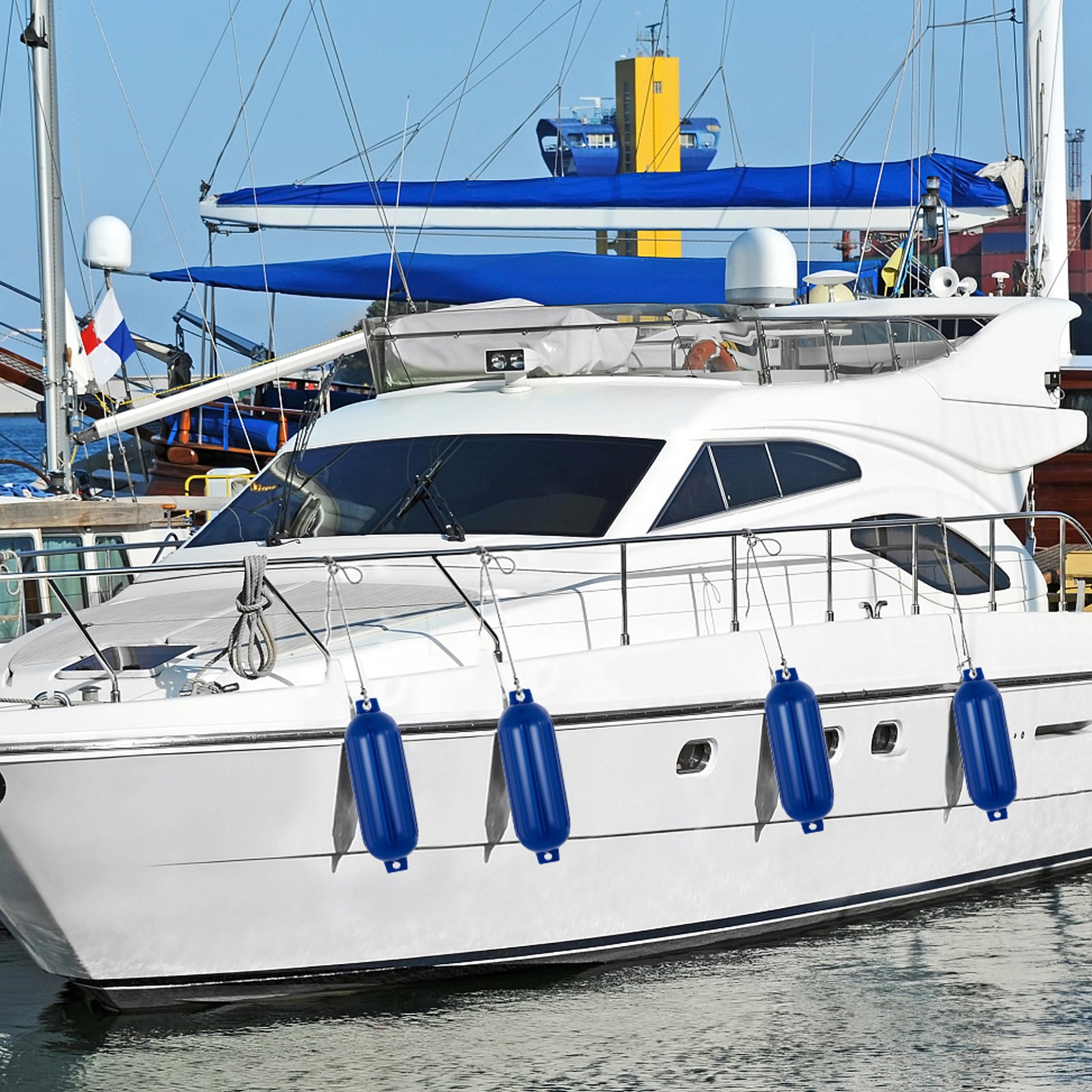 Yate blanco con defensas VEVOR azules atracado en un puerto deportivo.