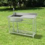 Fregadero utilitario de acero inoxidable VEVOR colocado al aire libre sobre césped verde con árboles al fondo.