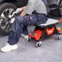 Mecánico usando el taburete de mecánico VEVOR mientras trabaja en un neumático de automóvil, con herramientas almacenadas debajo.