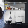 Mujer cocinando en una cocina moderna con protector contra salpicaduras, utensilios y especias de la gama VEVOR.