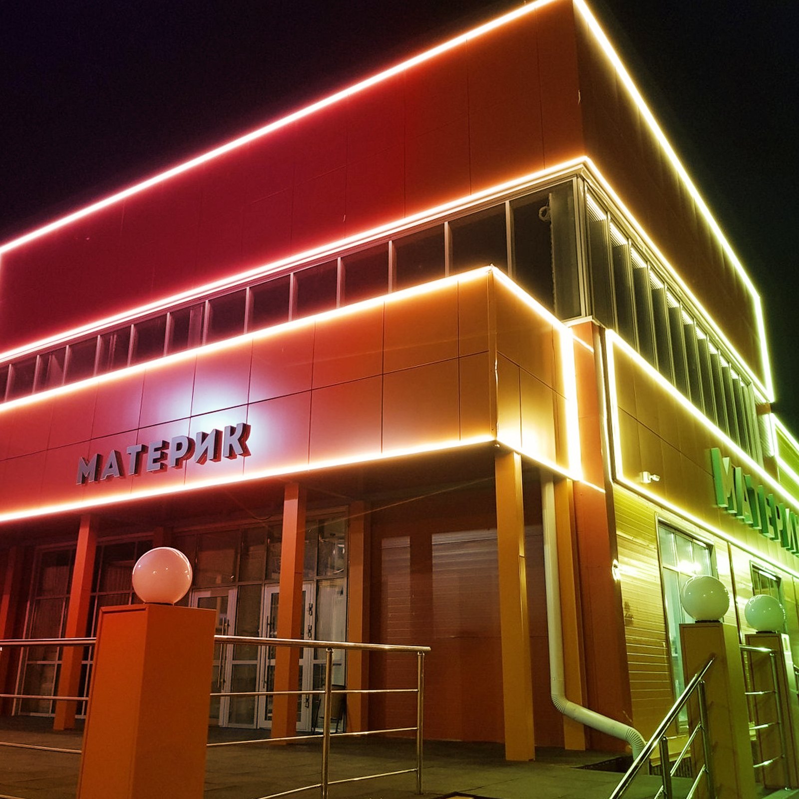 Escaparate moderno con vibrantes luces LED VEVOR en rojo y amarillo que iluminan el edificio.