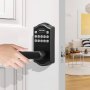 Mano usando la cerradura de puerta de entrada sin llave VEVOR en una puerta blanca, sala de estar moderna al fondo.