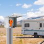 RV estacionado al fondo, cable de alimentación VEVOR de 15 pies para RV enchufado a una toma eléctrica exterior.