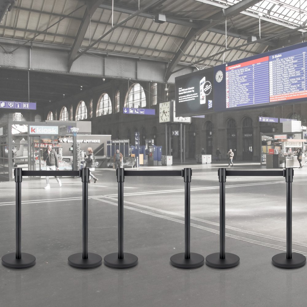 Puesto de control de multitudes VEVOR ubicado en una estación de tren moderna con personas y señalización.