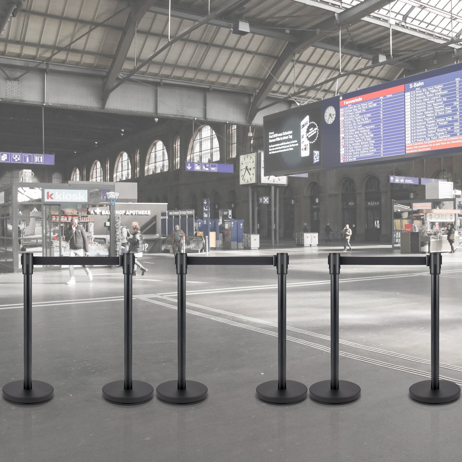 Puesto de control de multitudes VEVOR ubicado en una estación de tren moderna con personas y señalización.