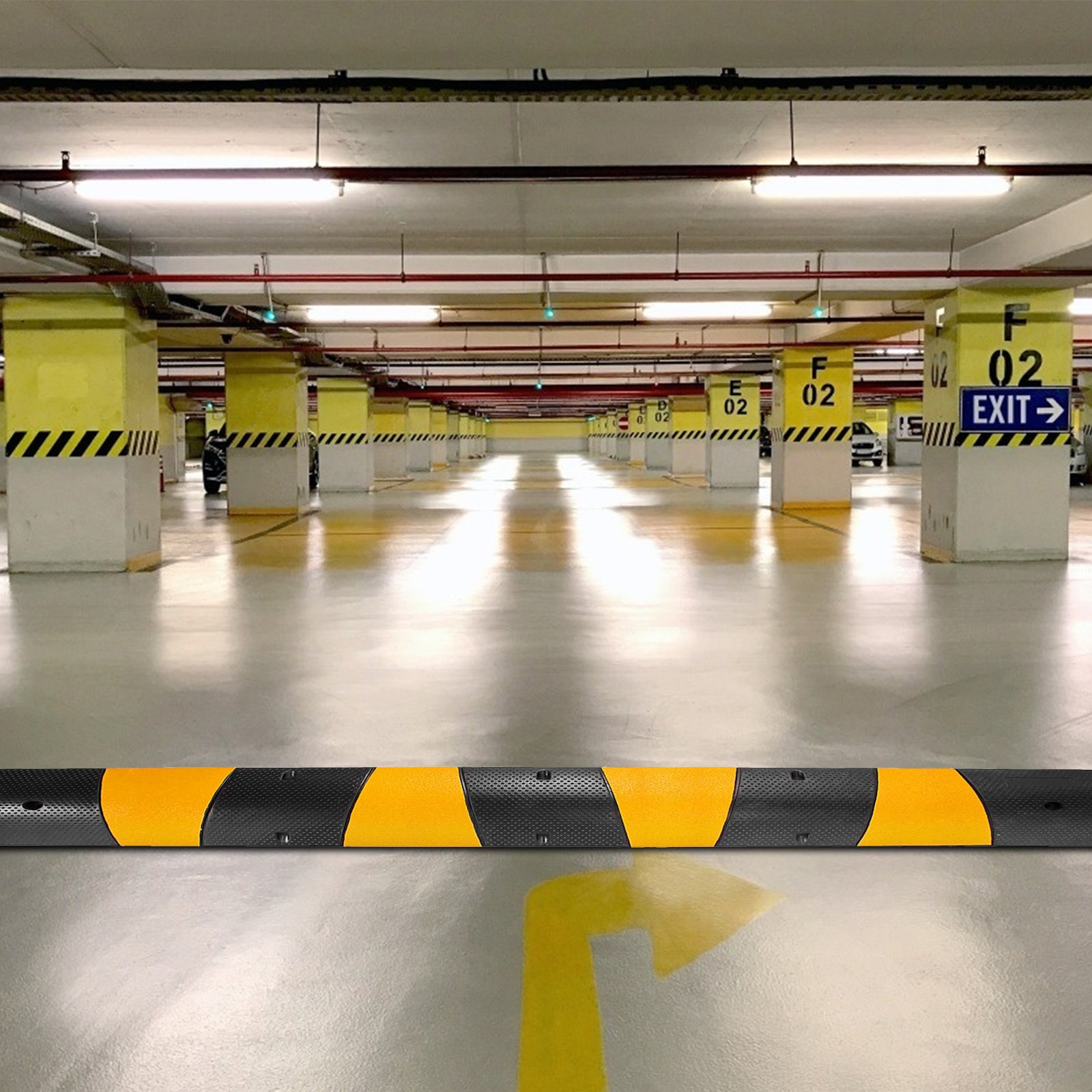 Rampa protectora de cables VEVOR en un estacionamiento subterráneo con marcas de seguridad amarillas.