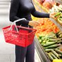 Cesta de supermercado VEVOR roja sostenida por una persona que selecciona verduras en el pasillo de un supermercado.