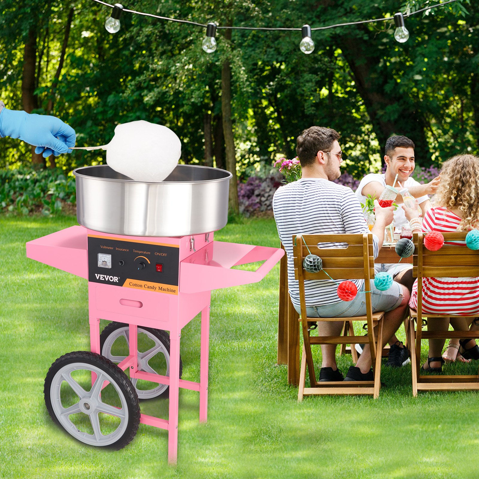 Máquina de algodón de azúcar VEVOR al aire libre con gente disfrutando de una fiesta en el jardín de fondo.