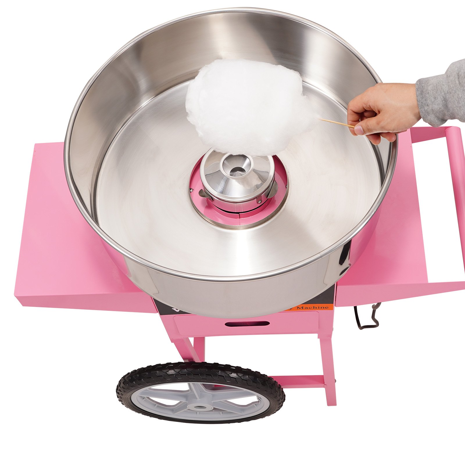mano sosteniendo algodón de azúcar sobre una máquina de algodón de azúcar VEVOR con carrito rosa y recipiente grande de acero.
