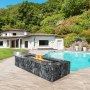 Patio al aire libre con protección contra el viento de vidrio VEVOR alrededor de una fogata cerca de una piscina y una casa moderna.