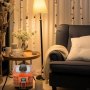 Transformador de voltaje VEVOR en una acogedora sala de estar con lámpara, sillón gris y mesa de madera.