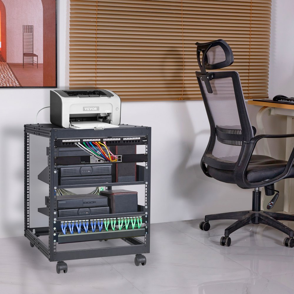 Configuración de oficina con rack de servidor VEVOR, cables de red, impresora, silla ergonómica y persianas.