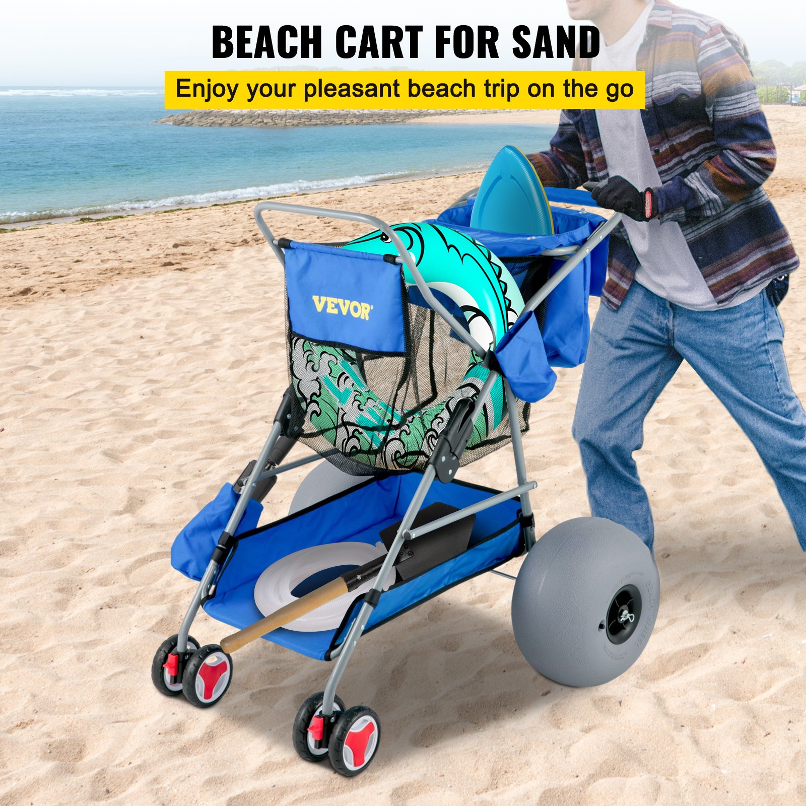 Carrito de playa VEVOR en color azul que transporta artículos de playa en la orilla arenosa con olas del océano de fondo.