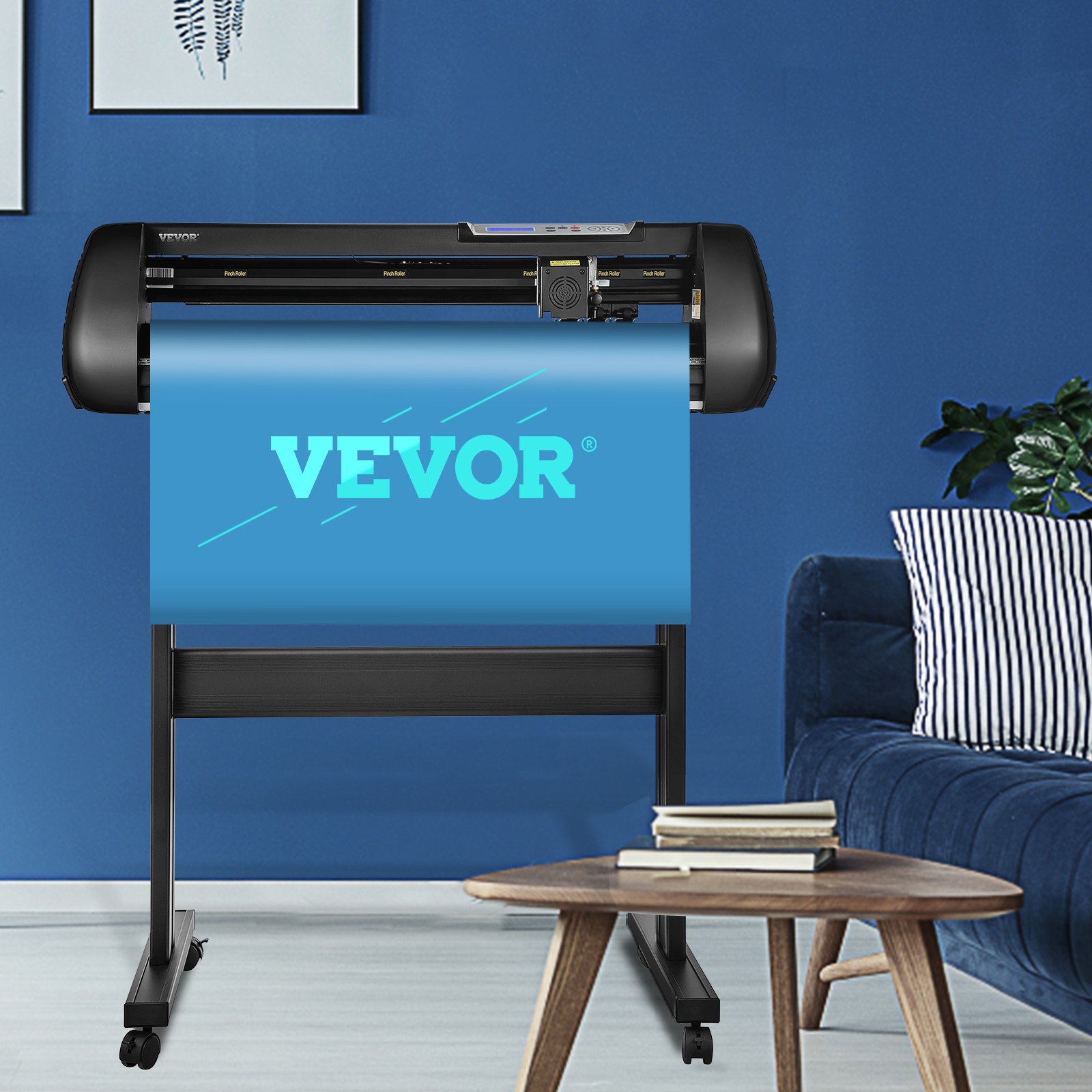 Máquina cortadora de vinilo VEVOR en una moderna oficina en casa con paredes azules y una acogedora zona de estar.