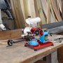 Afilador de hojas de sierra circular VEVOR en una mesa de taller con herramientas para trabajar la madera.