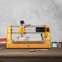 Máquina enrutadora CNC VEVOR sobre una superficie de madera con panel de control y herramientas cerca.