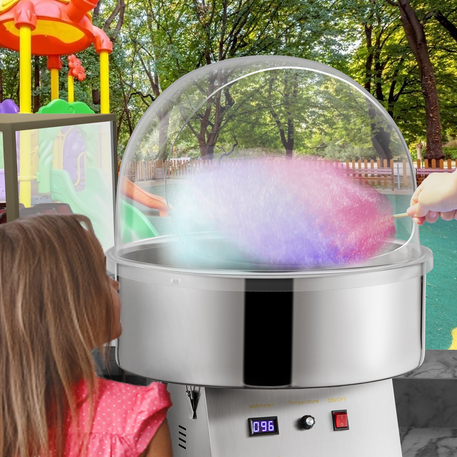 Niño mirando algodón de azúcar colorido en la cubierta de una máquina de dulces VEVOR en un patio de juegos.