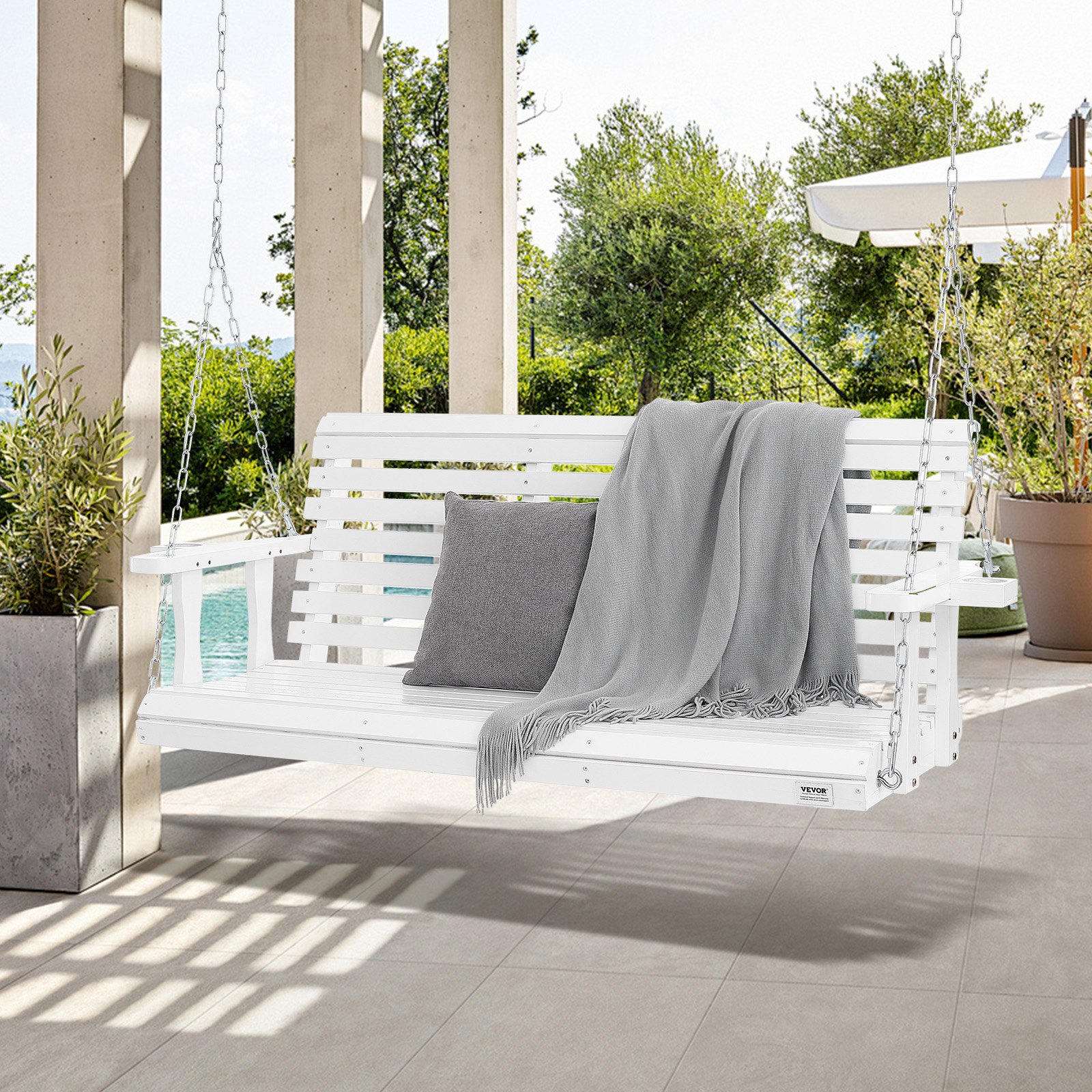 Columpio de porche de madera VEVOR blanco con cojines y manta colgado en un patio junto a la piscina.